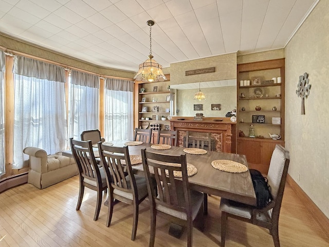 dining area featuring light wood-style floors, a baseboard radiator, and built in shelves