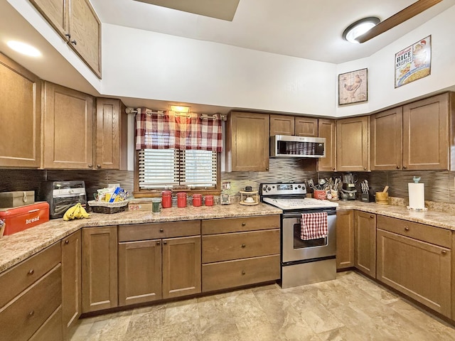 kitchen featuring light stone countertops, tasteful backsplash, and appliances with stainless steel finishes