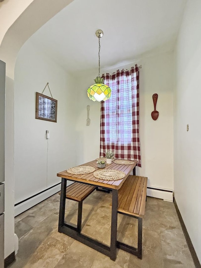 dining room featuring baseboards, a baseboard heating unit, and arched walkways