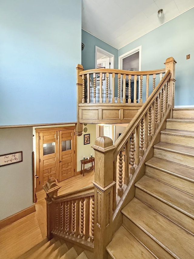 staircase featuring baseboards and wood finished floors