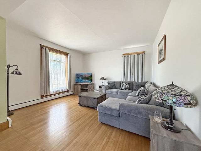 living area with a baseboard heating unit and wood finished floors