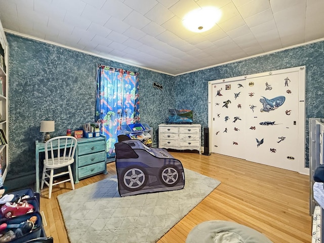 bedroom featuring ornamental molding and wallpapered walls