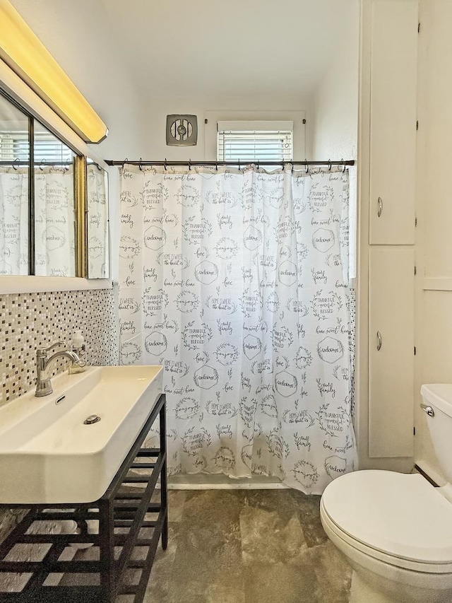 bathroom with shower / bath combo, a sink, backsplash, and toilet