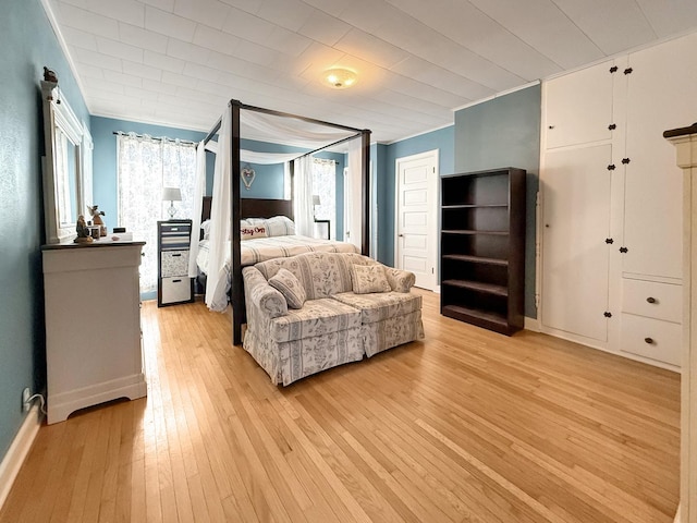 bedroom with light wood-style flooring and crown molding