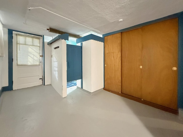 spare room featuring finished concrete flooring and a textured ceiling