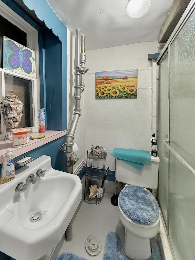 full bath featuring concrete flooring, a stall shower, a sink, and toilet