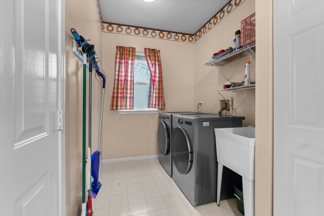 clothes washing area featuring baseboards, laundry area, and washer and dryer