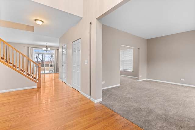 foyer with a chandelier, wood finished floors, stairs, and baseboards