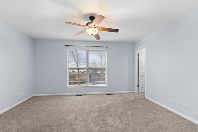 empty room featuring ceiling fan, carpet, and baseboards