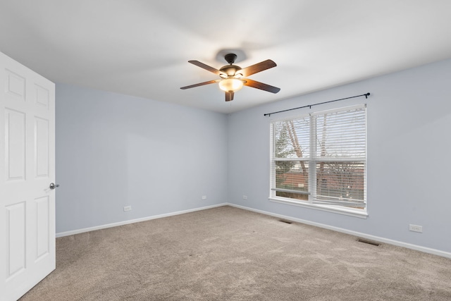 carpeted empty room with a ceiling fan, visible vents, and baseboards