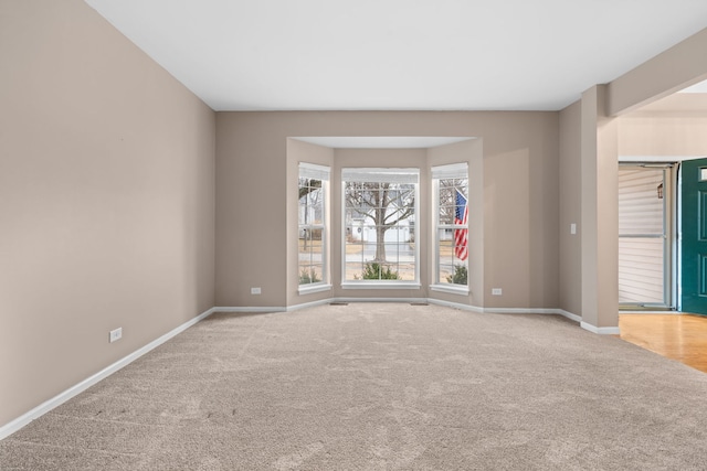 carpeted spare room featuring baseboards