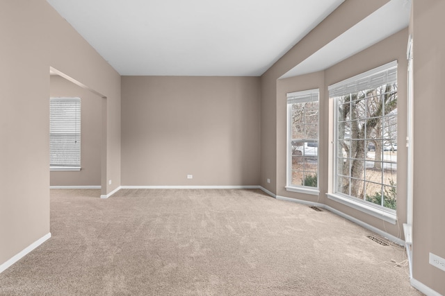 carpeted empty room with baseboards, visible vents, and a healthy amount of sunlight