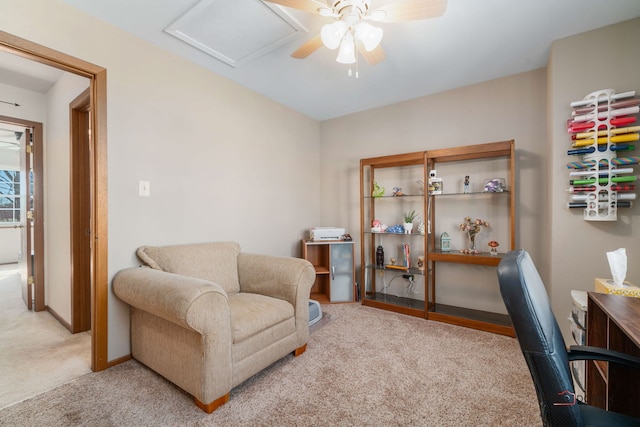 living area with carpet floors, a ceiling fan, attic access, and baseboards