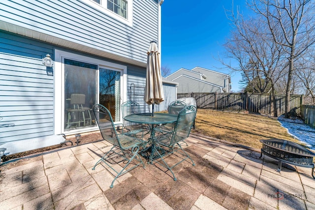 view of patio featuring an outdoor fire pit, outdoor dining area, and a fenced backyard