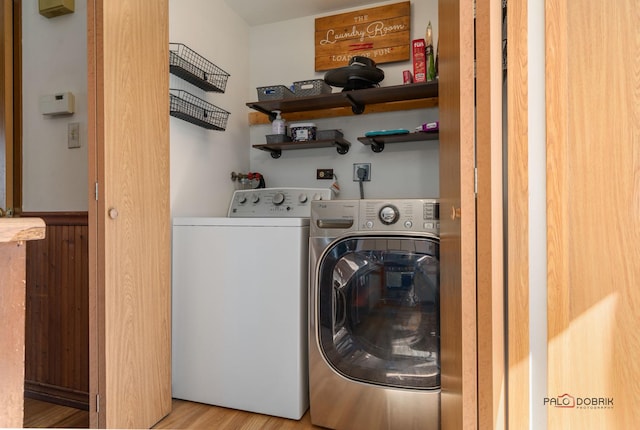 laundry area with washing machine and dryer, laundry area, and wood finished floors