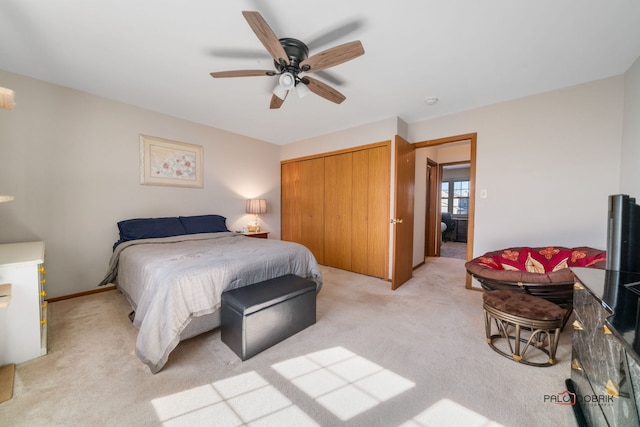 bedroom featuring a ceiling fan, a closet, and light carpet