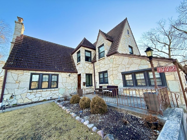 view of front facade featuring stone siding and a chimney