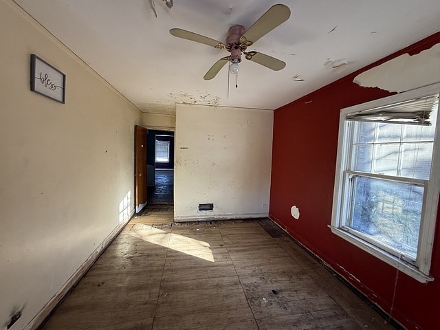 unfurnished room featuring ceiling fan and a wealth of natural light