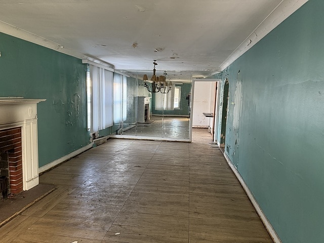 hall featuring baseboards and a chandelier