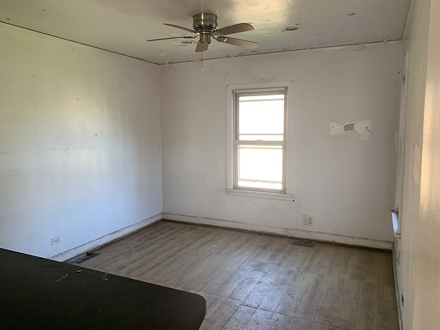 unfurnished room with a ceiling fan and wood finished floors