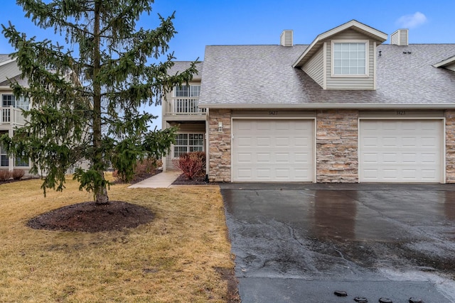 view of front facade featuring a garage, stone siding, roof with shingles, and driveway