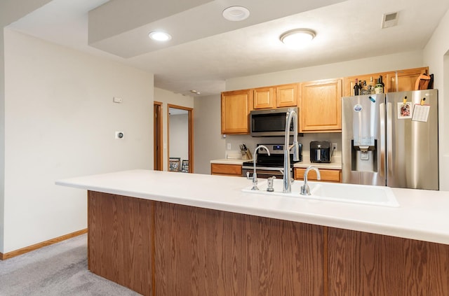 kitchen featuring light countertops, appliances with stainless steel finishes, a sink, and visible vents