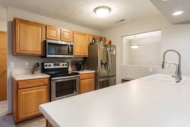 kitchen with visible vents, stainless steel appliances, a sink, and light countertops