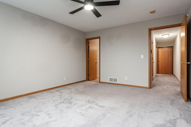 unfurnished bedroom with light carpet, a ceiling fan, visible vents, and baseboards