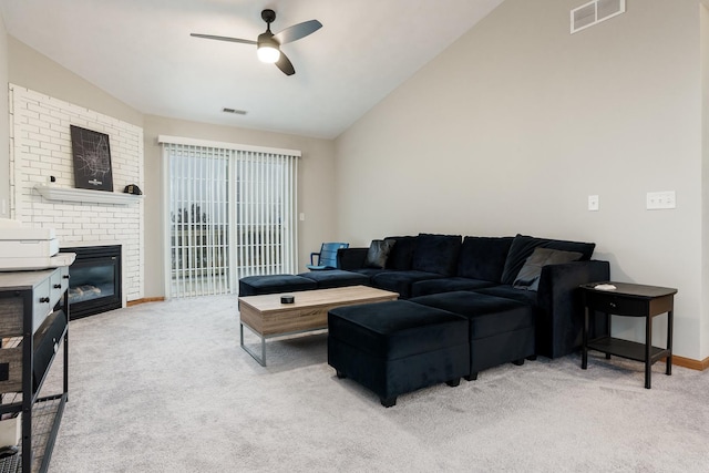 living area featuring light colored carpet, lofted ceiling, a brick fireplace, and visible vents