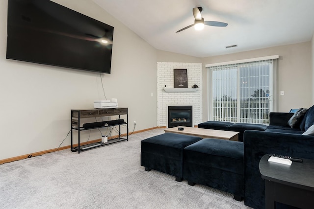 carpeted living room with lofted ceiling, visible vents, a ceiling fan, baseboards, and a brick fireplace