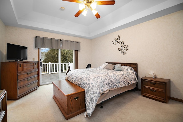 bedroom with light carpet, baseboards, a ceiling fan, access to exterior, and a tray ceiling