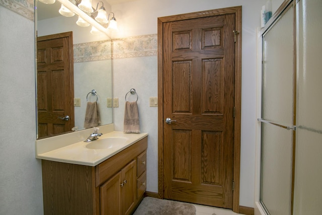 bathroom with a notable chandelier, a shower with door, and vanity