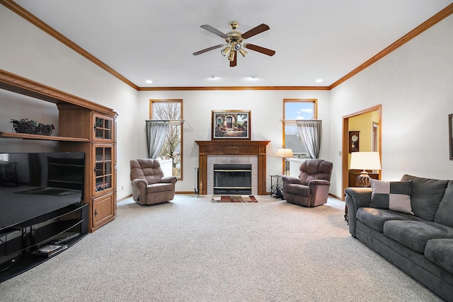 carpeted living room with a wealth of natural light, ceiling fan, baseboards, and a tile fireplace