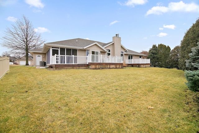 back of house with a sunroom, a deck, cooling unit, and a yard