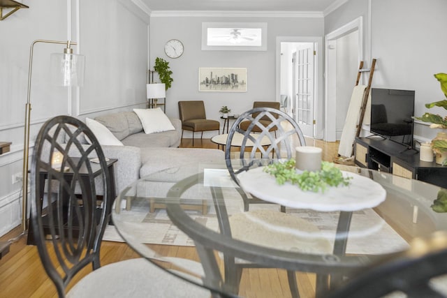 living room with ceiling fan, ornamental molding, and wood finished floors