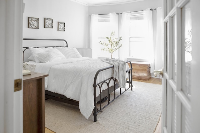 bedroom featuring crown molding and wood finished floors