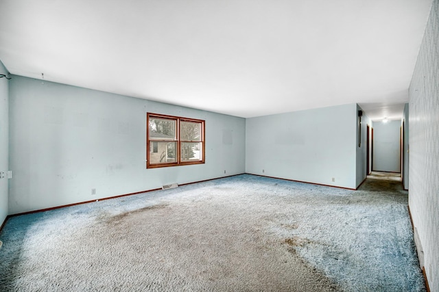 empty room featuring carpet floors, baseboards, and visible vents