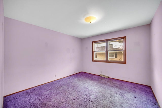 carpeted spare room featuring baseboards and visible vents