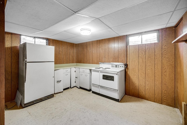 kitchen featuring white appliances, light countertops, and wood walls