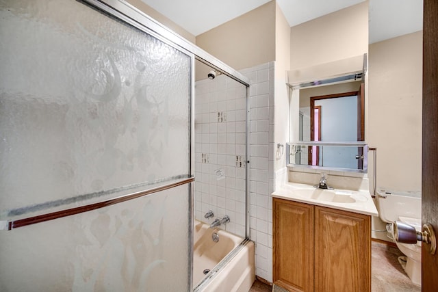 full bathroom featuring toilet, combined bath / shower with glass door, and vanity