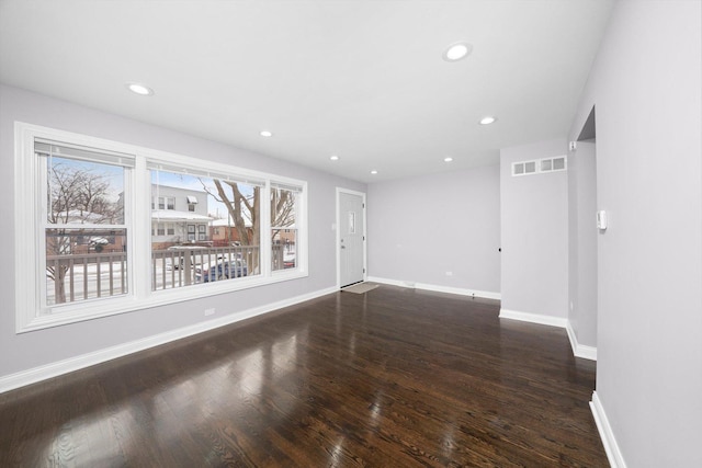 unfurnished room featuring recessed lighting, wood finished floors, visible vents, and baseboards