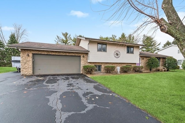 split level home featuring aphalt driveway, an attached garage, and a front yard