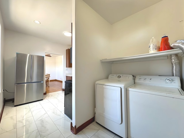 washroom featuring laundry area, washer and clothes dryer, and baseboards