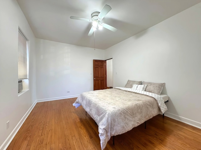 bedroom with wood finished floors, a ceiling fan, and baseboards