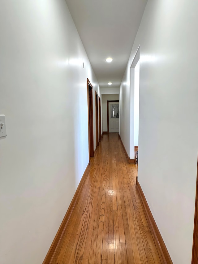 hallway with baseboards and light wood finished floors