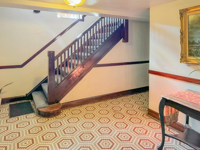 stairway featuring a healthy amount of sunlight and baseboards