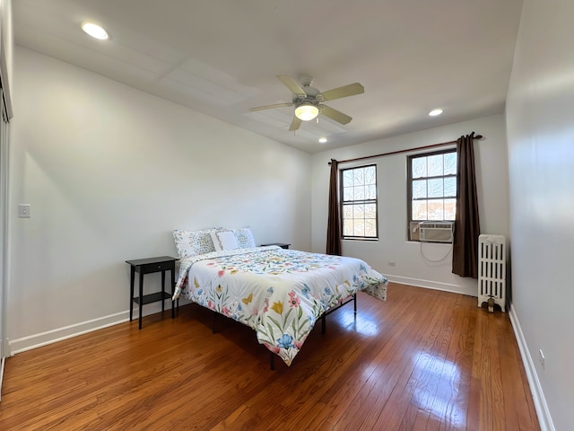 bedroom featuring recessed lighting, hardwood / wood-style floors, radiator heating unit, a ceiling fan, and baseboards