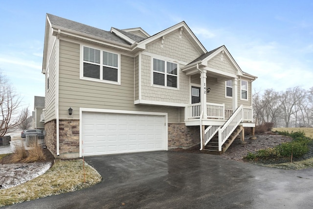 view of front of property with stone siding, aphalt driveway, and an attached garage