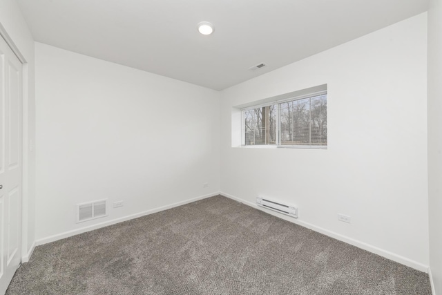 carpeted empty room with a baseboard radiator, visible vents, and baseboards