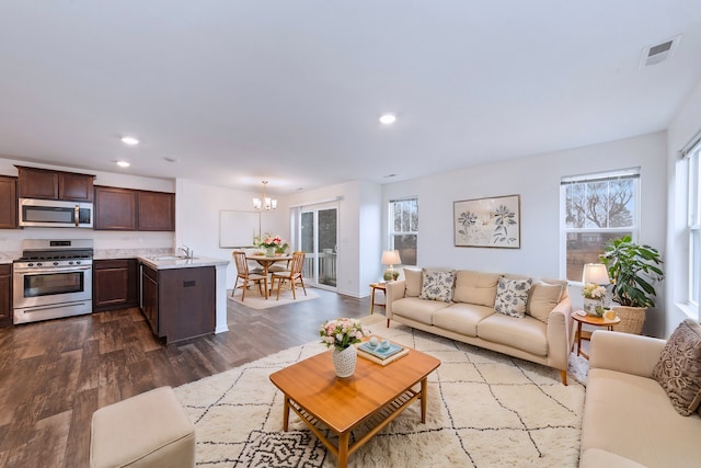 living room featuring a healthy amount of sunlight, dark wood-style floors, visible vents, and recessed lighting